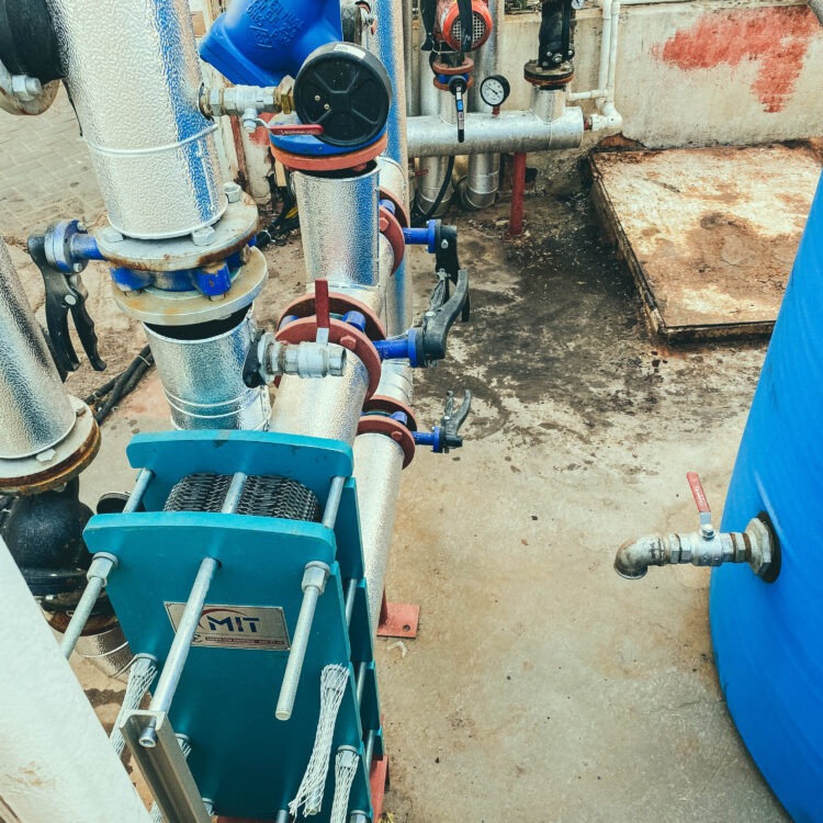 utility room. gray metal structures. on designs of blue valves with red switches. factory building, water treatment.