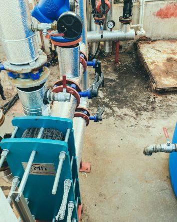 utility room. gray metal structures. on designs of blue valves with red switches. factory building, water treatment.